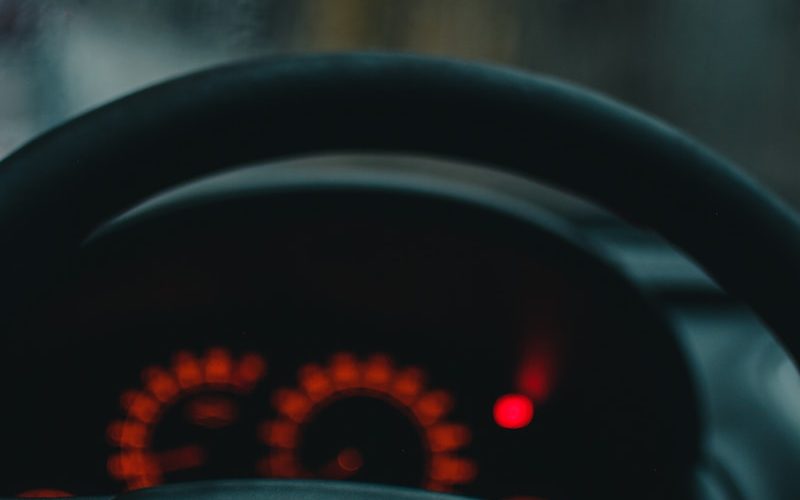 the dashboard of a car with a red light on